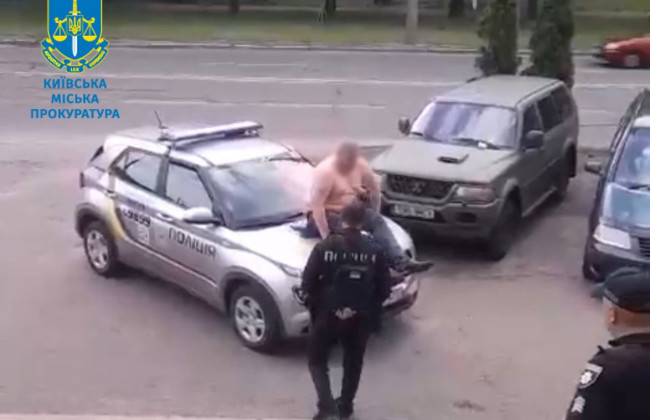 В Киеве мужчина залез на капот авто полиции и ударил правоохранителя: фото и видео