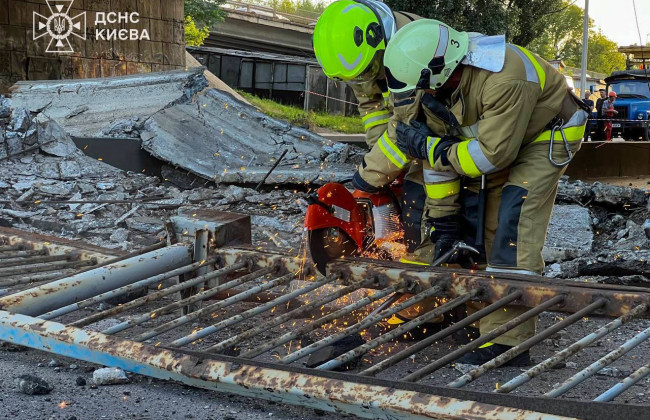 В Киеве расчищают дорогу от разрушенных конструкций моста, фото